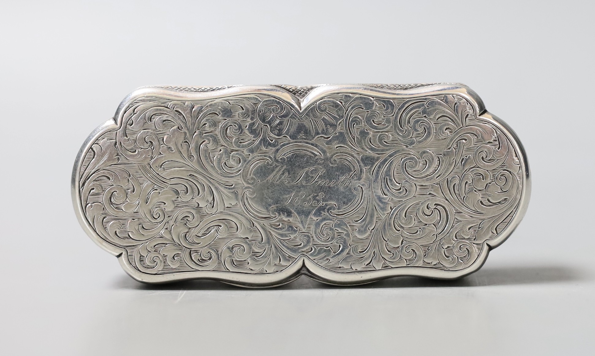 A Victorian engraved silver shaped oval snuff box, by Nathaniel Mills, Birmingham, 1840, with later engraved inscription, 95mm.